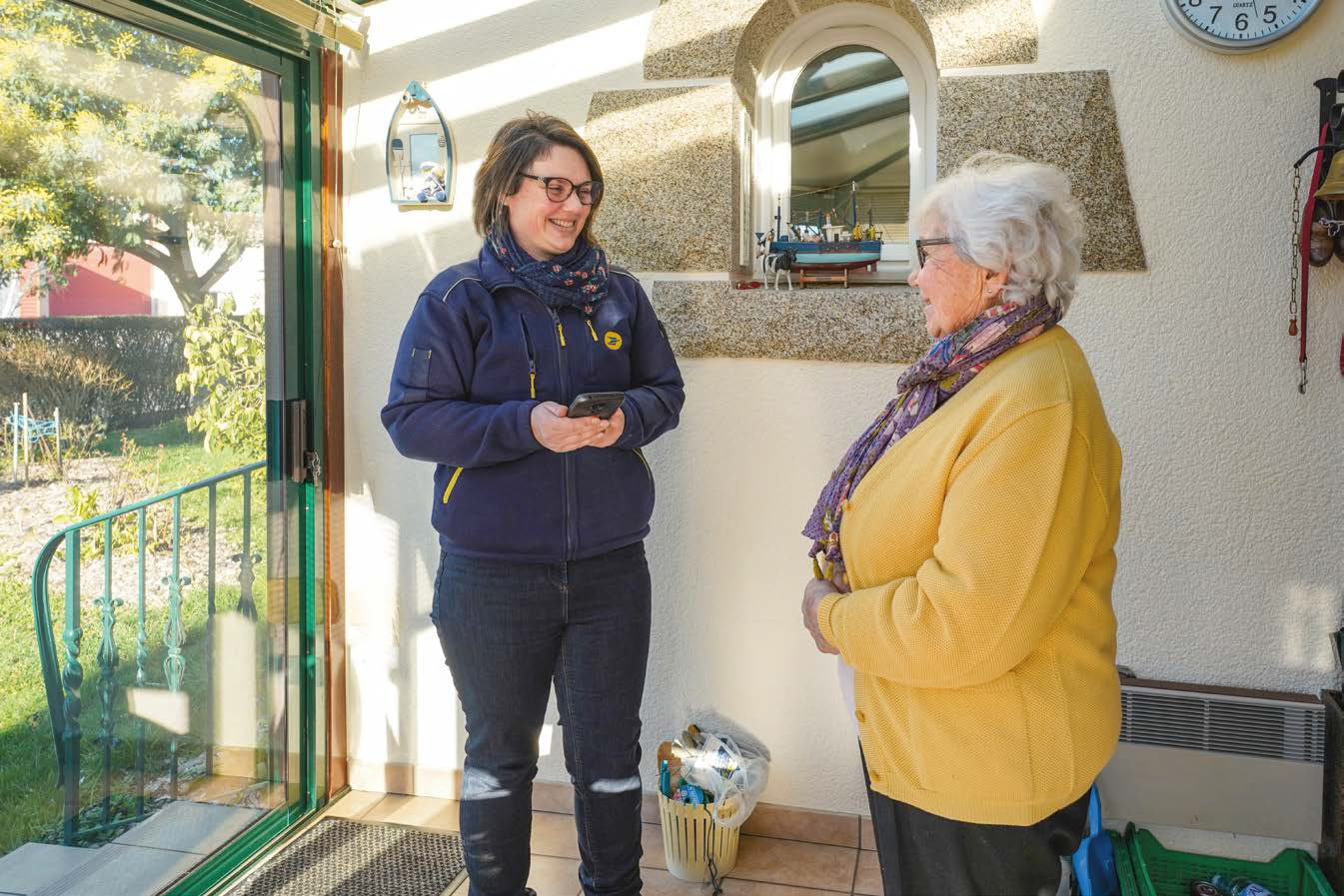 Photo d'illustration réalisée par La Poste Santé et Autonomie : Une agente de La Poste Livre des médicaments au domicile d'une patiente. Soins à domicile. Autonomie. Parcours santé. Parcours de soin